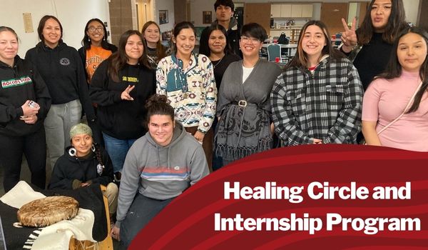 15 of the 17 youth participating in the healing circle and incternship program standing together for a group photo in workshop space next to a drum.